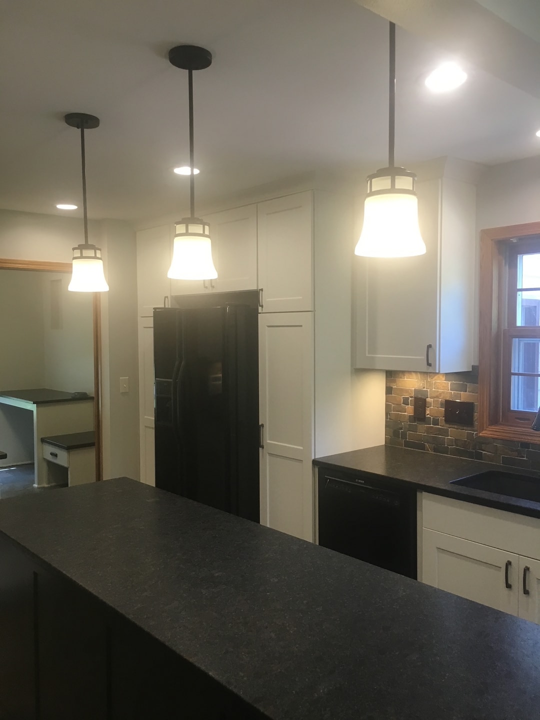 Modern kitchen with pendant lights and dark countertop island